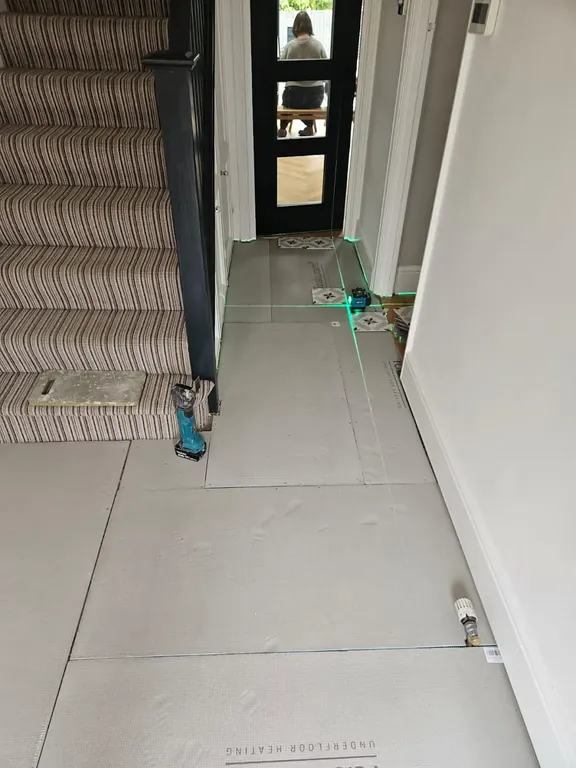Hallway floor boarded out and screw-fixed from the front door to the stairs, ready for tiling.