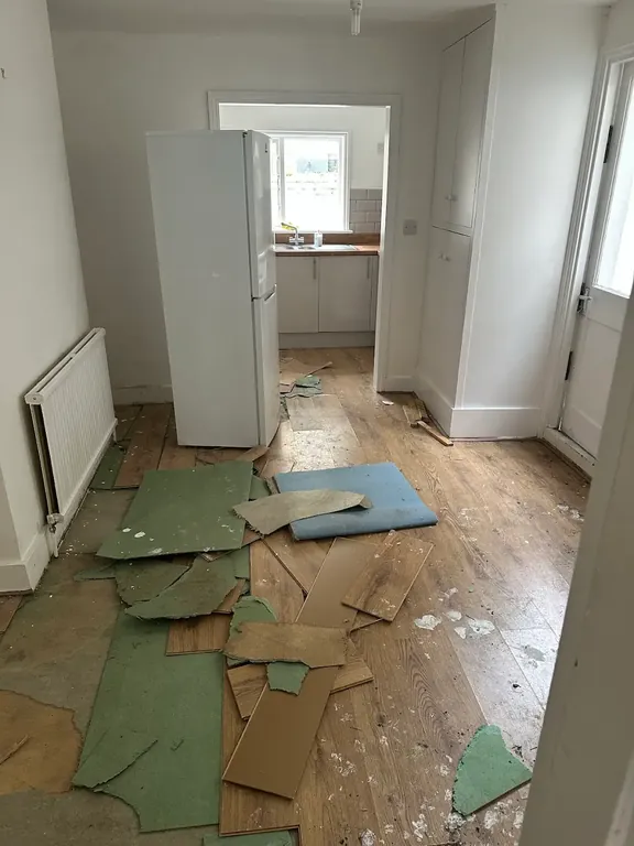 Kitchen and dining floor stripped back to bare boards with the old covering and underlay broken up and lifted.